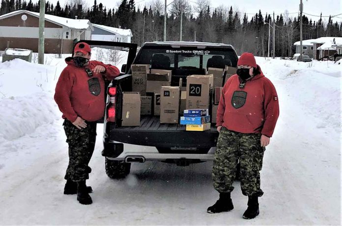 Rangers Jody Grenier and Curtis Waboose deliver food to homes in Ginoogaming in bitter cold temperatures. credit Warrant Officer Carl Wolfe