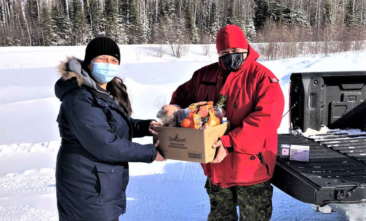 Community member Tracy Dore receives a box of Covid emergency supplies from Ranger Jody Grenier. credit Warrant Officer Carl Wolfe