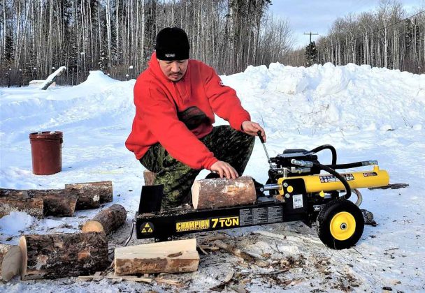 Master Corporal Shaun Kakegamic uses a wood splitter to prepare firewood for elders in Muskrat Dam. credit Sergeant Emily Beardy, Canadian Rangers