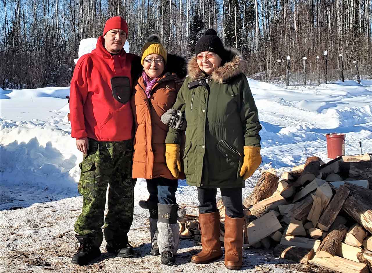 Master Corporal Shaun Kekegamc takes a break from cutting wood to talk with Elders Irene Ross and Flora Beardy.