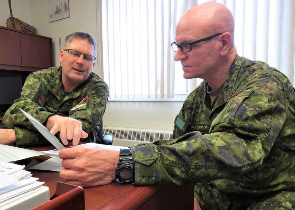 Lieutenant-Colonel Shane McArthur, who commands the Canadian Rangers of Northern Ontario, left, discusses a problem with Chief Warrant Officer Robert Patterson.