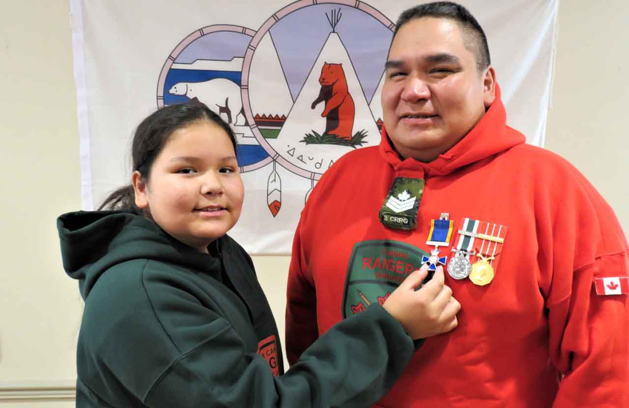 Sergeant Matthew Gull has the insignia of the Order of Military Merit placed on his uniform by his daughter Amelia, 12. She is a Junior Canadian Ranger. Credit Sergeant Peter Moon,Canadian Rangers