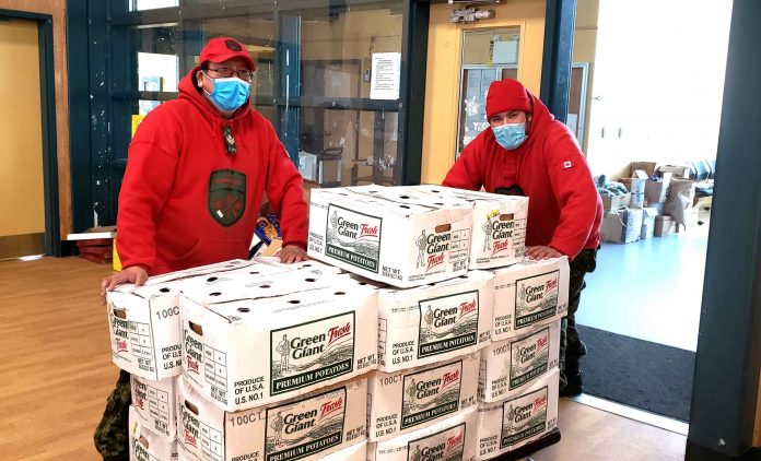 Master Corporal Leo Oskineegish from Nibinamik, left, and Ranger Kyle Linklater of Moose Factory organize emergency food supplies for Mishkeegogamang First Nation. Both Rangers are members of a mobile Ranger team that flew to the community to help it in its COVID crisis. Credit Sergeant Richard Mifflin, Canadian Army