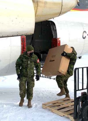 Canadian Rangers Eli Owen and Rob Turtle begin to unload a resupply aircraft in Pikangikum. Photo credit Master Warrant Officer Fergus O'Connor, Canadian Army