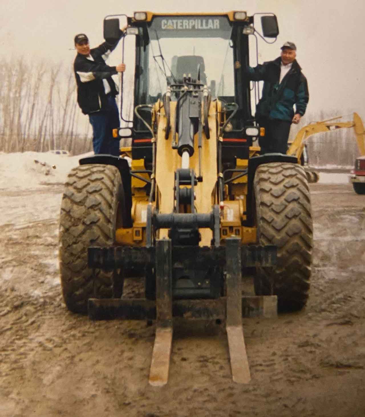 photo submitted by Paul Kataquapit Purchasing their first major piece of equipment, a Caterpillar front end loader, is Paul Kataquapit on the left and his late father Marius Kataquapit.