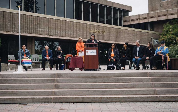 Elder Catherine McGuire provides remarks during the Survivors' Flag raising earlier today at Lakehead University. Special guests included (from left), Councillor BessAnn Legarde of Fort William First Nation, Dr. Gillian Siddall, Lakehead's President and Vice-Chancellor, Denise Baxter, Lakehead's Vice-Provost Indigenous Initiatives, Deputy Grand Chief Anna Betty Achneepineskum of Nishnawbe Aski Nation, Ace Hashim, VP Advocacy with Lakehead University Student Union, Dominic Pasqualino, Acting Mayor of the City of Thunder Bay, Dante Miecznikowski from Red Sky Métis Independent Nation, and Elder and Senator Grant Robbins of the Thunder Bay and District Metis Council