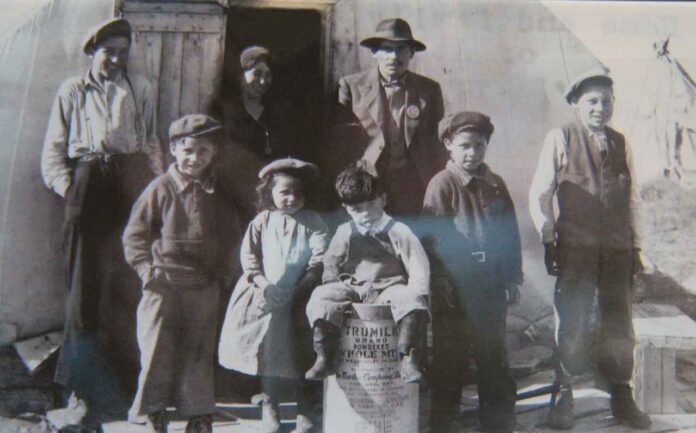 photo supplied by Kataquapit family This faded historical photo features my grandfather James Kataquapit who was Chief of Attawapiskat in 1945. Here we see him standing with a hat and pin signifying his leadership. His wife Janie Kataquapit is standing at the door. Chief Kataquapit was also a veteran of the First World War. From L-R are his children: Thomas, Marius, Celine, David, Gabriel and Alex. Missing are brothers George and Leo.