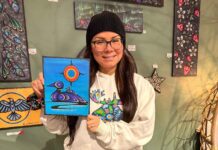 Kids bring Indigenous art to life with coding at Thunder Bay Public Library Artist Jessica Mamakeesick posing with her painting, Mother Loon.