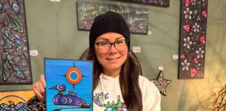 Kids bring Indigenous art to life with coding at Thunder Bay Public Library Artist Jessica Mamakeesick posing with her painting, Mother Loon.