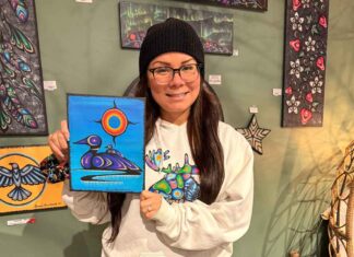 Kids bring Indigenous art to life with coding at Thunder Bay Public Library Artist Jessica Mamakeesick posing with her painting, Mother Loon.