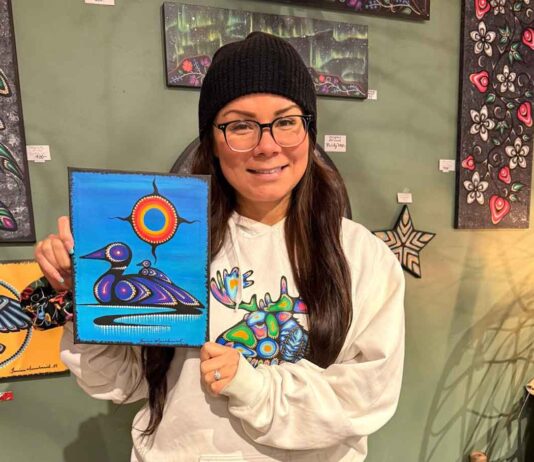 Kids bring Indigenous art to life with coding at Thunder Bay Public Library Artist Jessica Mamakeesick posing with her painting, Mother Loon.